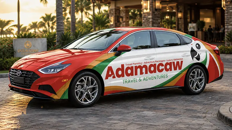 Adamacaw Vehicle Wrap Design 2 MOBILE Adamacaw Travel & Adventures sedan wrap with red, green and gold tropical graphics outside a resort